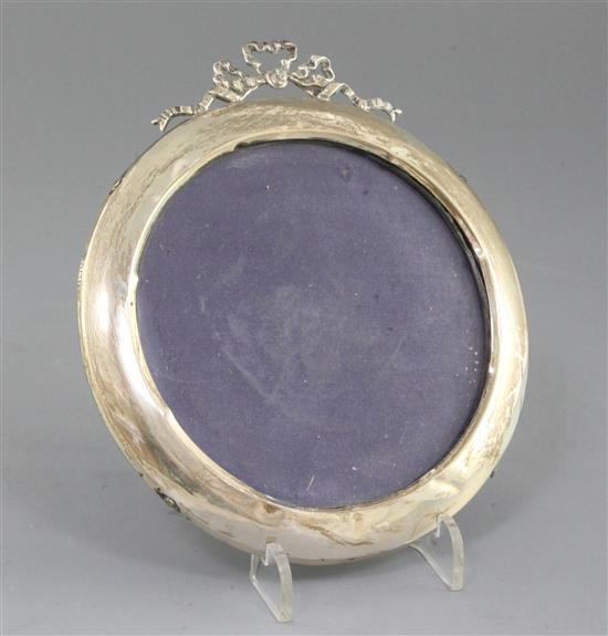 A George V circular silver mounted photograph frame, with ribbon crest, 15cm.